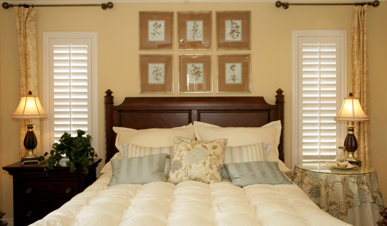 Bedroom with two tall plantation shutters on either side of bed in Salt Lake City 